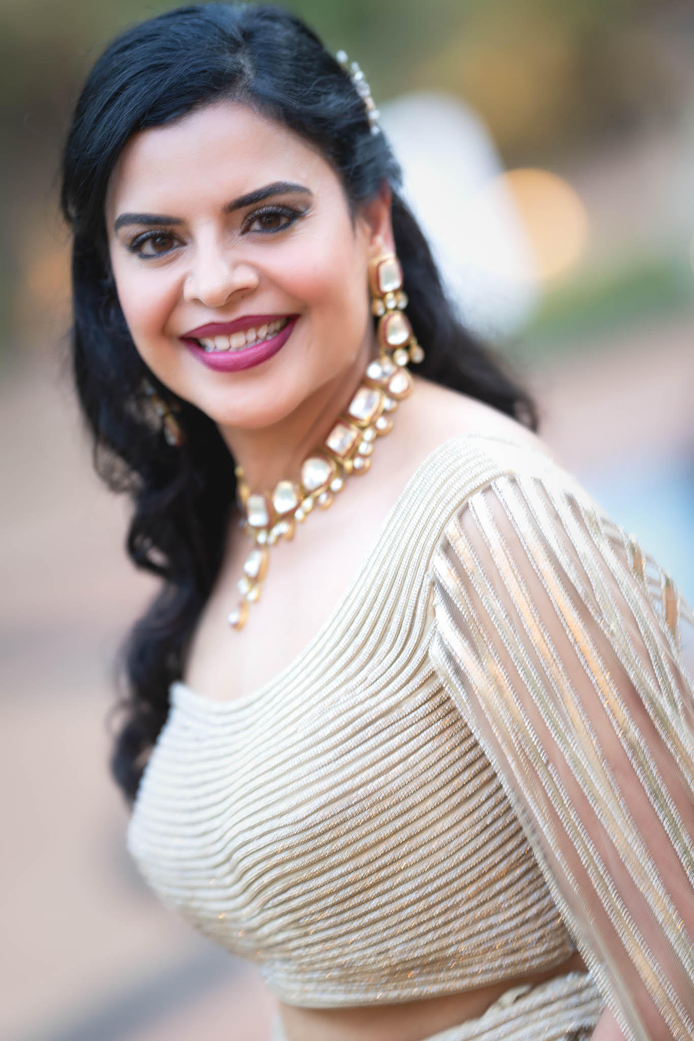 Traditional Indian formal attire features vibrant colors, intricate designs, and statement jewel-toned accessories.